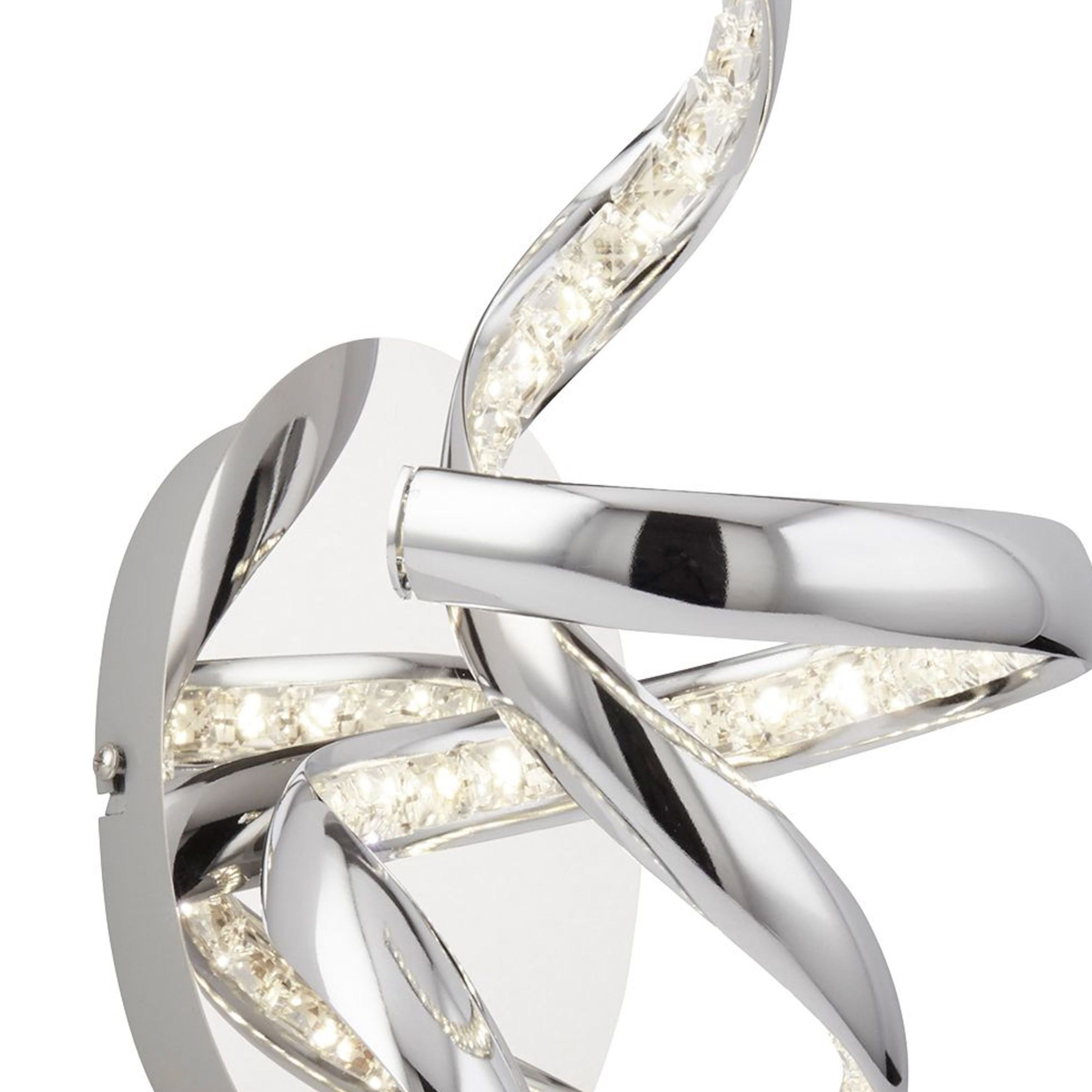Close-up of a modern chrome spiral LED wall light with embedded crystals.