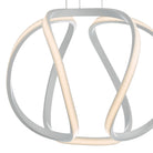 Close-up of the illuminated, curved chrome loops of a modern pendant light.