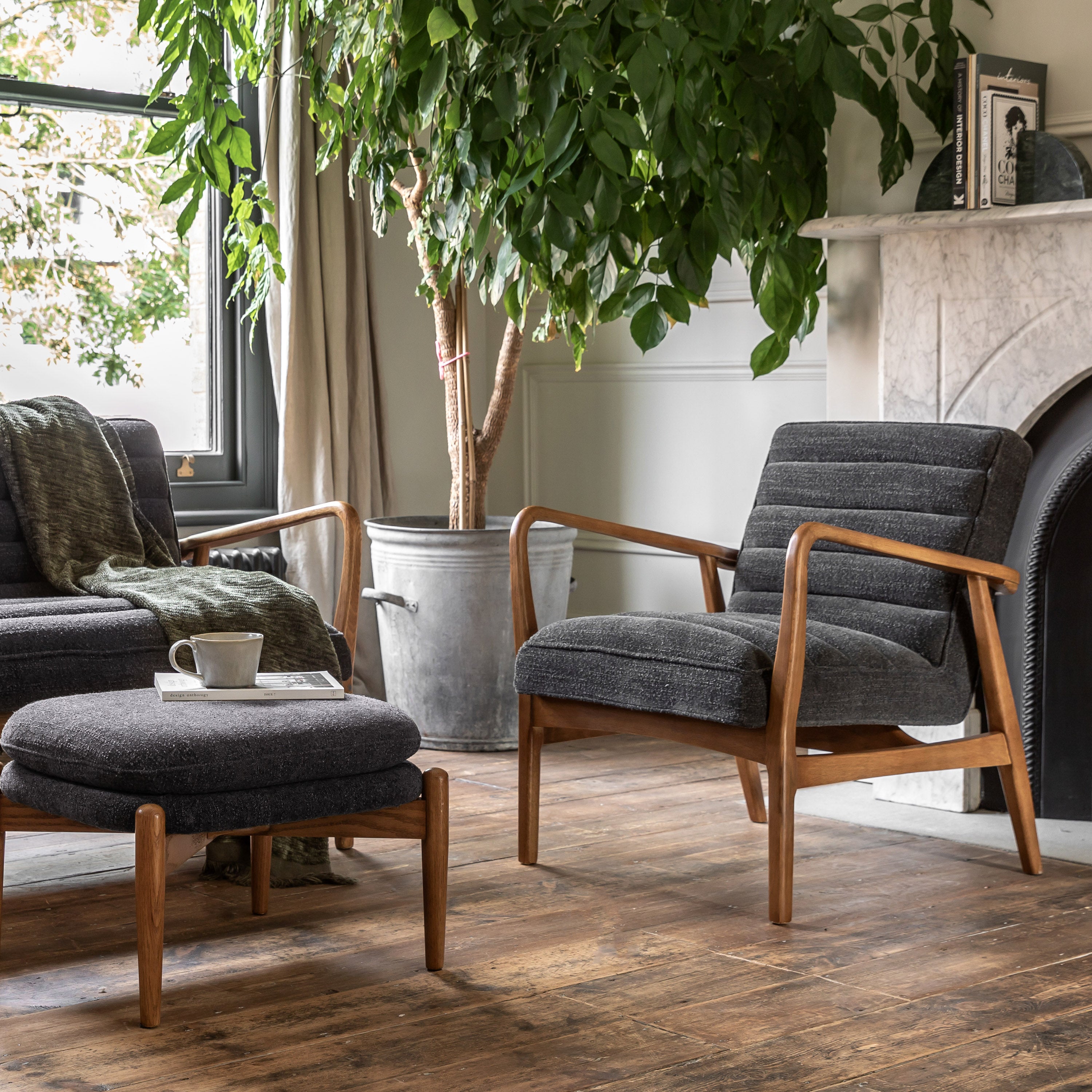 Two gray upholstered armchairs and an ottoman in a cozy living room setting.