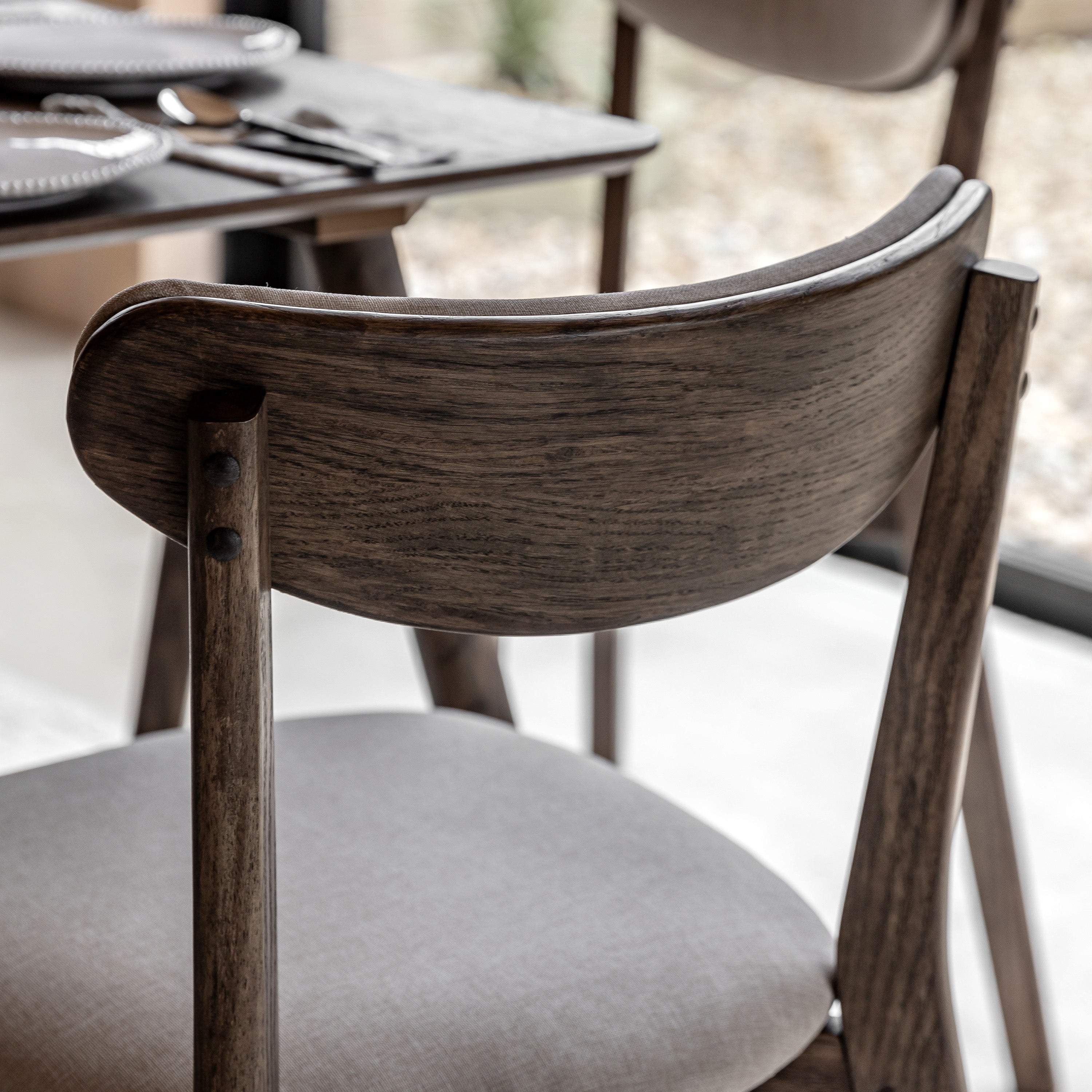 A detailed close-up of the wooden backrest of a dining chair, showcasing its grain.
