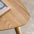 Close-up of a wooden table surface with a book placed on top.