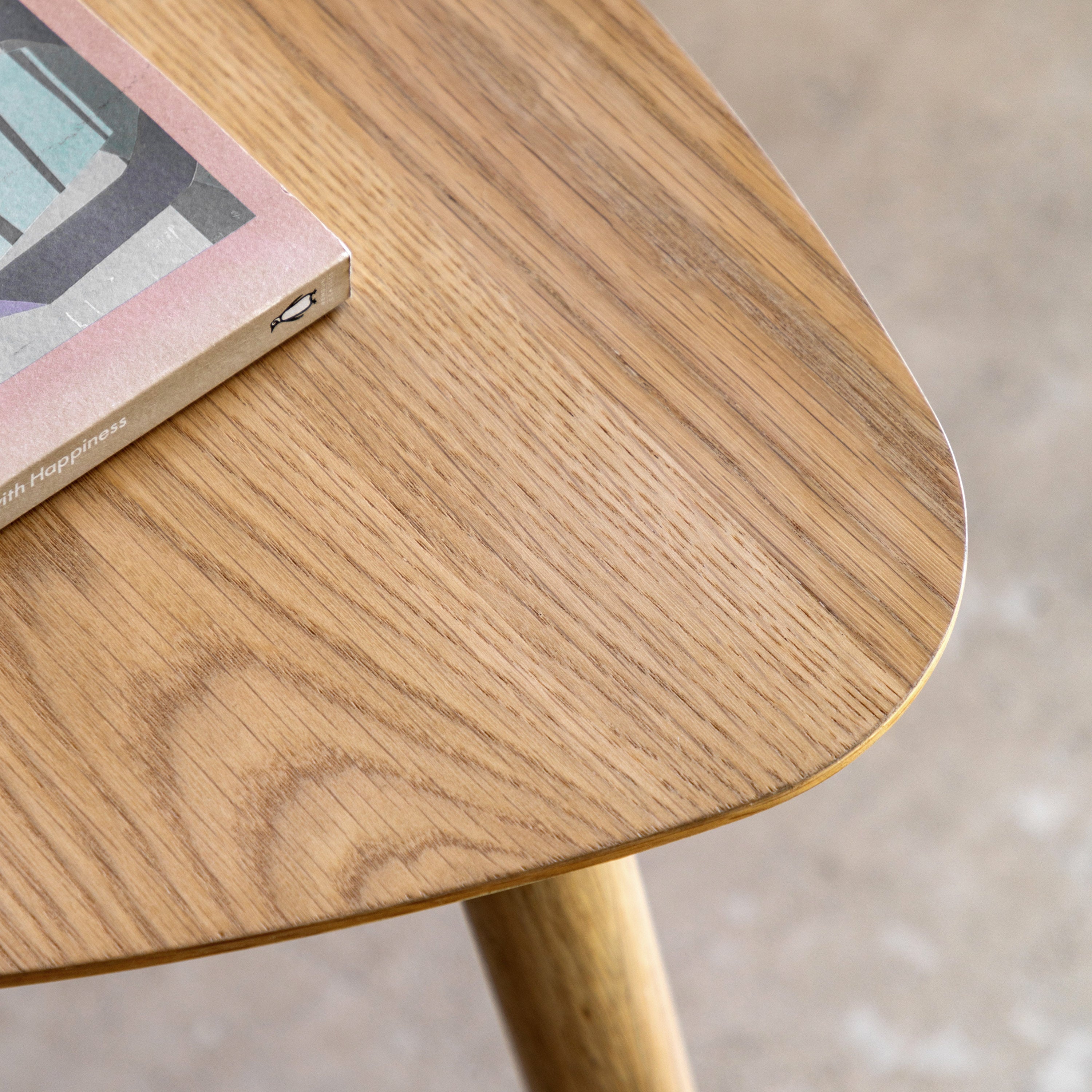 Close-up of a wooden table surface with a book placed on top.