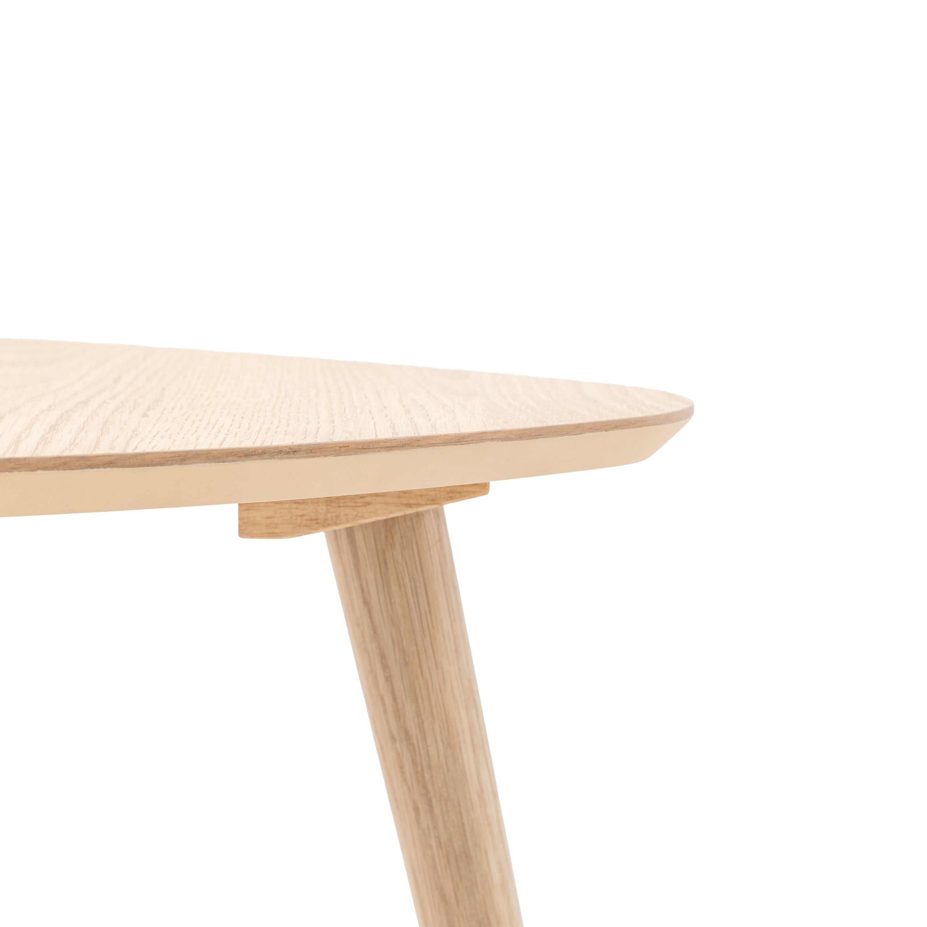 Close-up of the light wood triangular tabletop and one of its legs.