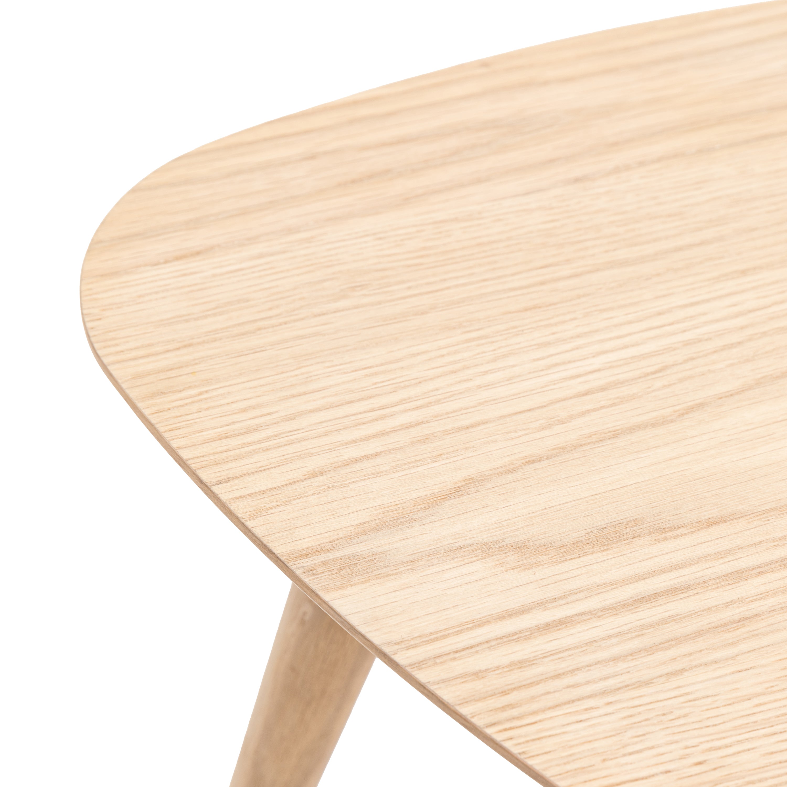 Close-up of the smooth, light wood grain of a triangular table surface.