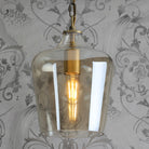 A close-up view of the pendant light with the bulb illuminated.