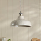 A white textured pendant light fixture suspended from the ceiling in a modern interior.