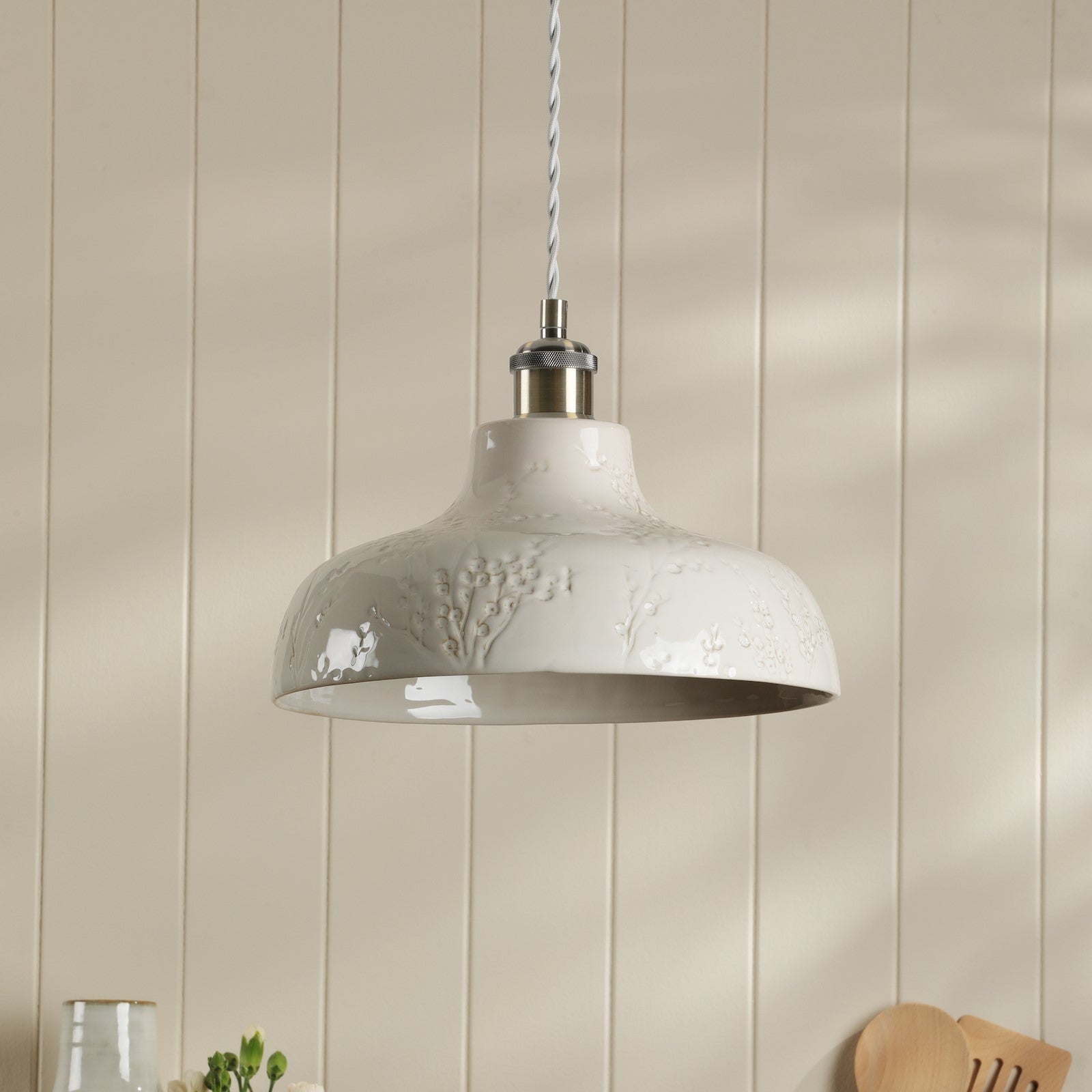 A white textured pendant light fixture suspended from the ceiling in a modern interior.