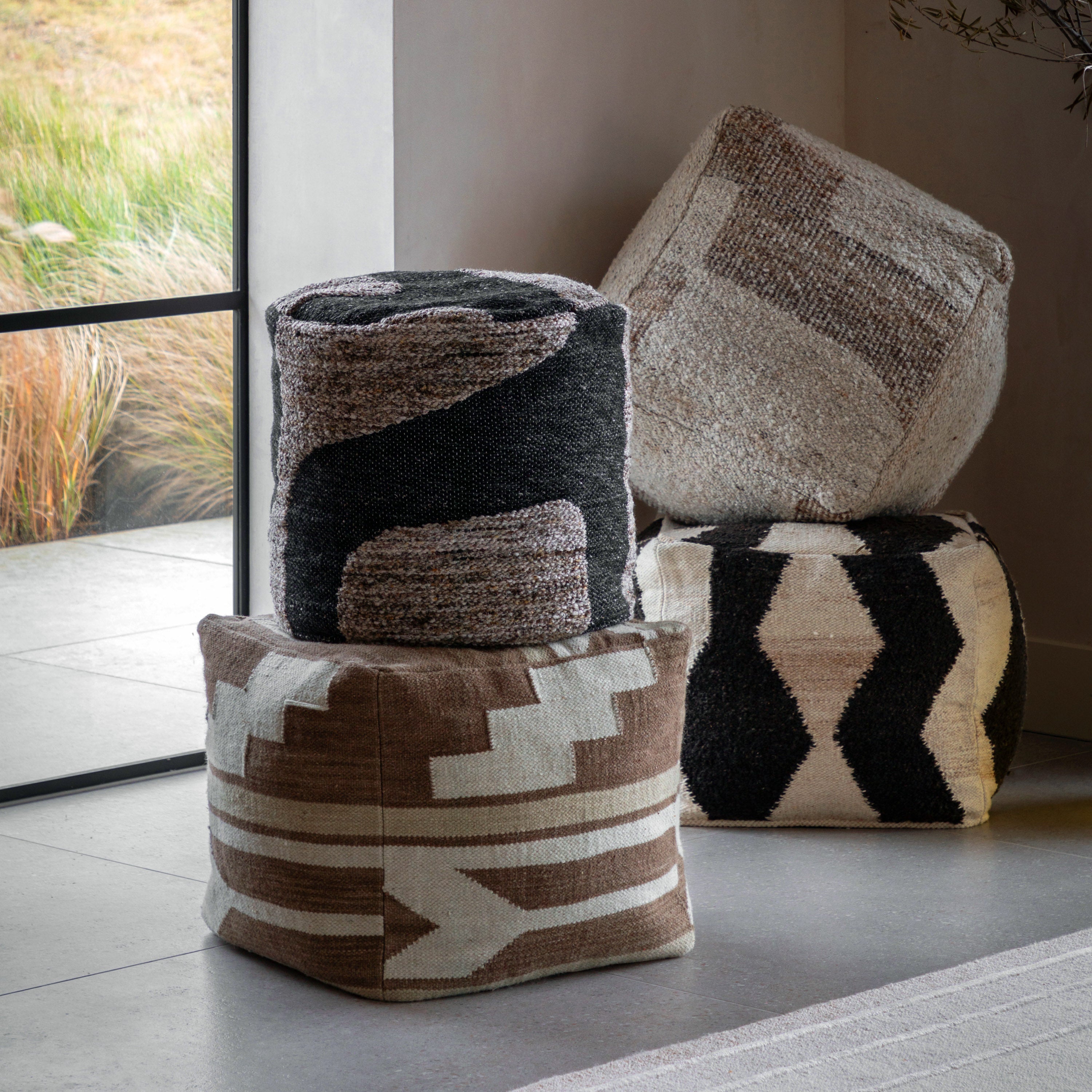 Four poufs with different patterns in a living room.