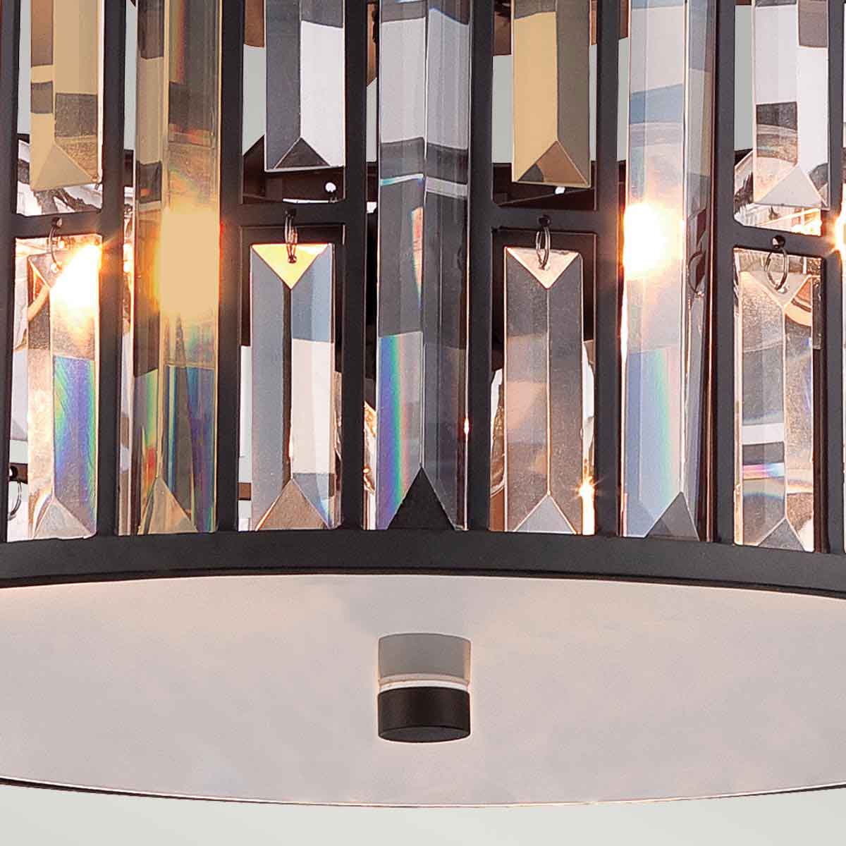 Detail of the bottom and side crystals of a bronze flush mount light fixture.