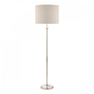 A tall, elegant floor lamp with a cream fabric shade and a polished silver base.