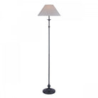 A full-length shot of a classic floor lamp with a dark base and a light-colored shade.