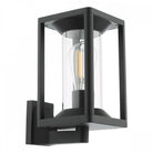 A black outdoor wall light with an exposed LED filament bulb inside a clear glass cylinder.