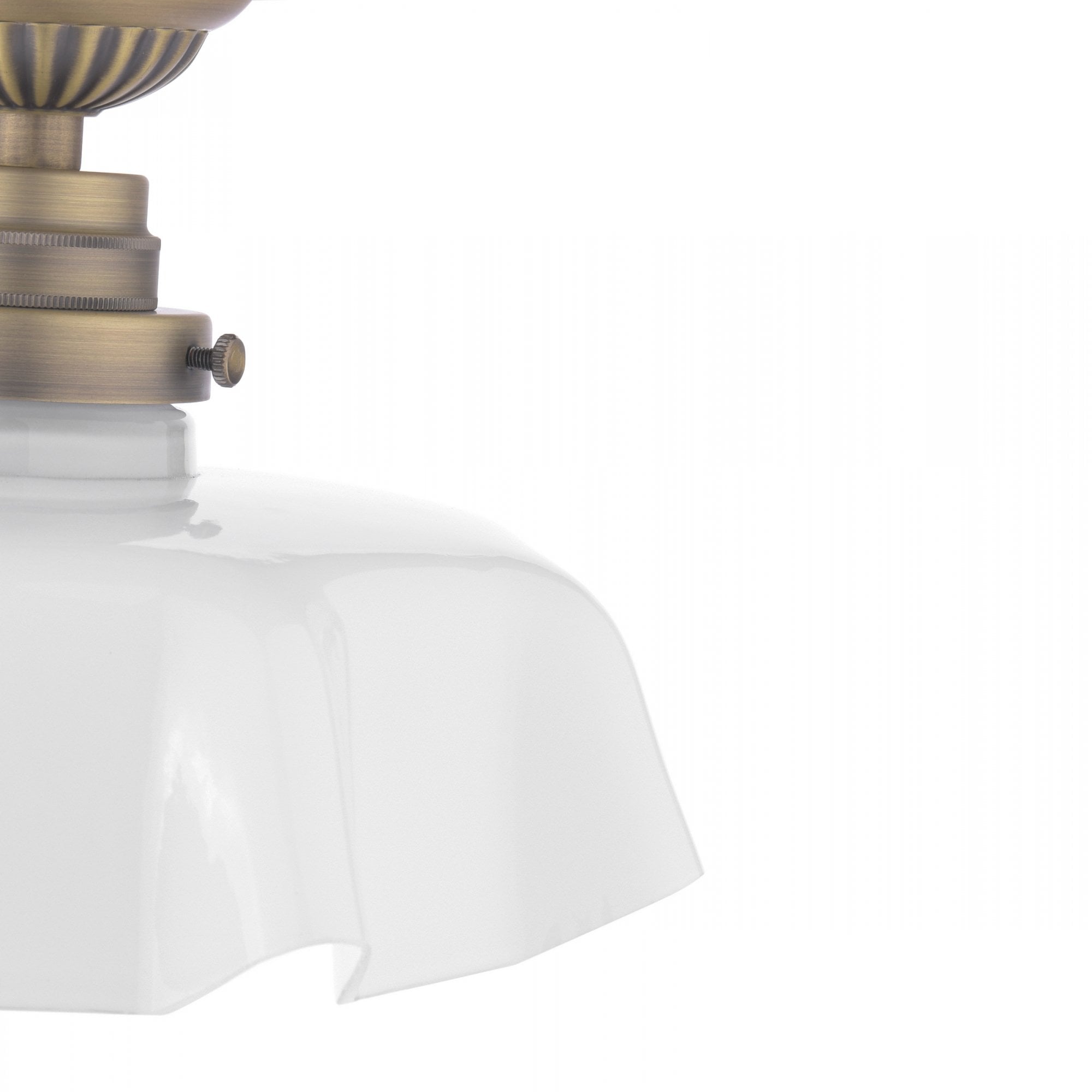 A close-up of the ruffled glass shade of a brass ceiling light.