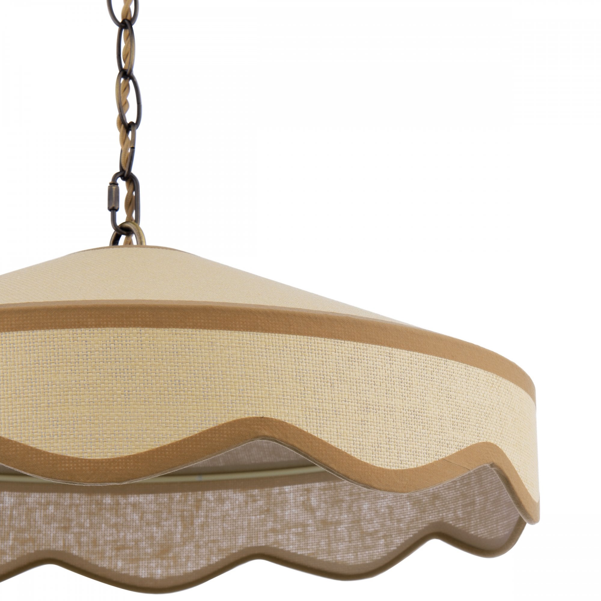 A close-up view of the cream-colored shade and wavy trim of a hanging ceiling light.
