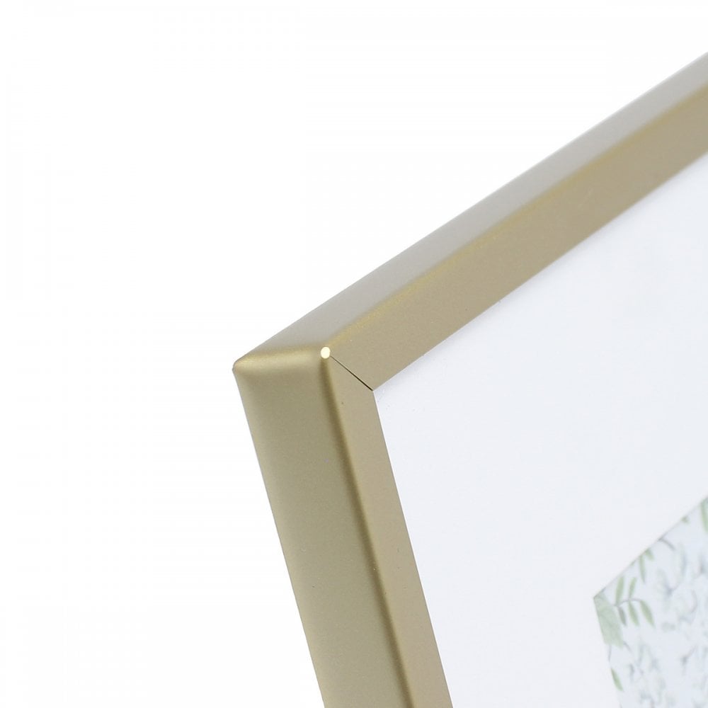 Close-up view of the corner of a gold picture frame with a white mat.