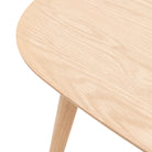 Detailed view of the light wood grain on the corner of a contemporary table, highlighting craftsmanship.